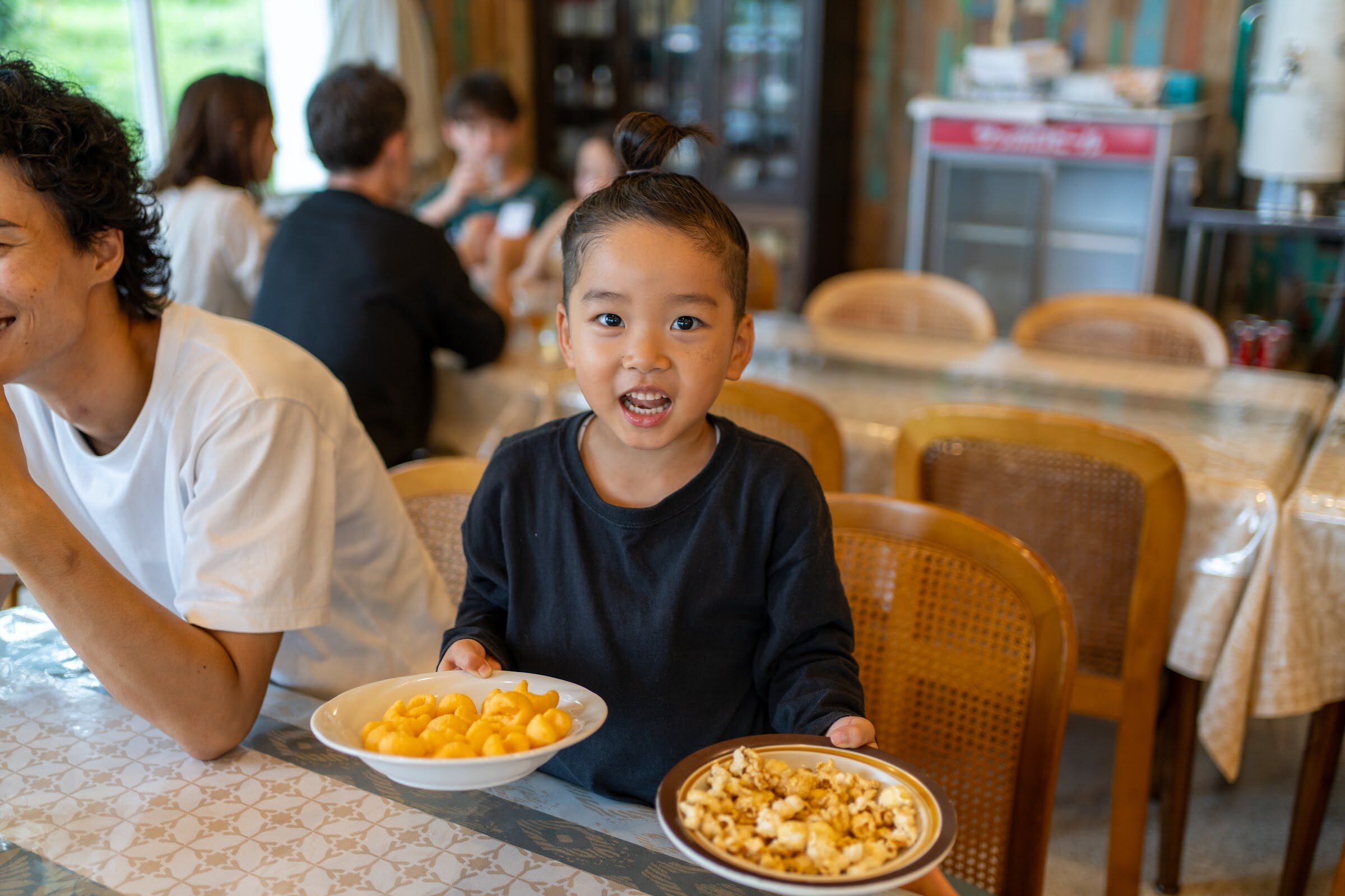 食堂で料理の皿を運んでくる子ども